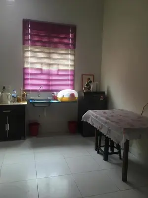 a kitchen with a table and a purple window at Cozy Corner Homestay in Kepala Batas
