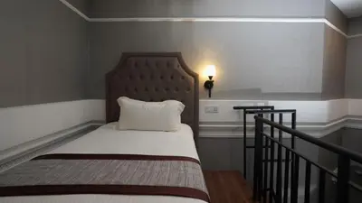 a small bedroom with a bed with a headboard at 1969 Business Suites @ Ipoh Garden in Ipoh