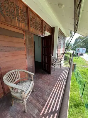 two chairs sitting on a porch of a house at Suri Homestay, Taiping in Taiping