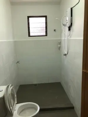a bathroom with a toilet and a shower with a window at Suri Homestay, Taiping in Taiping