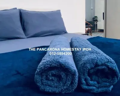 a bed with two large blue towels on it at The Pancarona Homestay forMuslims, Ipoh, Perak in Ipoh