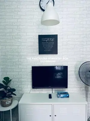 a flat screen tv sitting on top of a white cabinet at The Pancarona Homestay forMuslims, Ipoh, Perak in Ipoh