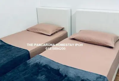 two beds sitting next to each other in a bedroom at The Pancarona Homestay forMuslims, Ipoh, Perak in Ipoh