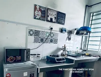 a kitchen with a counter top with a microwave at The Pancarona Homestay forMuslims, Ipoh, Perak in Ipoh