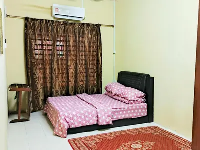 a bedroom with a bed with pink sheets at RIZQI HOMESTAY Sungai Siput with Wifi! Islamic Guest Only! in Kampong Rimba Panjang
