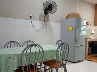 a kitchen with a table with chairs and a refrigerator at RIZQI HOMESTAY Sungai Siput with Wifi! Islamic Guest Only! in Kampong Rimba Panjang