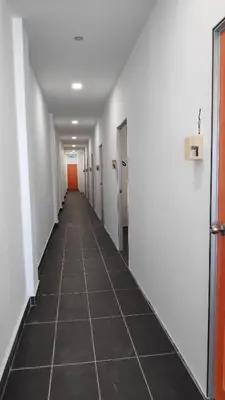 an empty hallway with white walls and a tile floor at YipStay in Gopeng