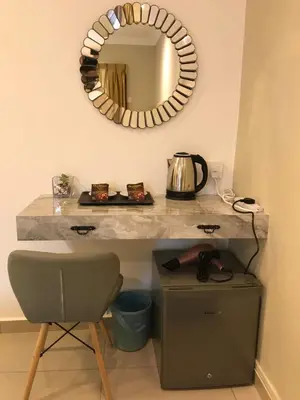 a counter with a mirror and a table with a chair at Art Heritage at Lucky 7 in Ipoh