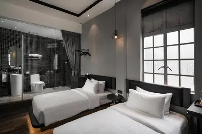 a bedroom with two beds and a bathroom with a shower at Modern Hotel Georgetown in George Town
