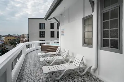 a balcony with white chairs and a pool on a building at Modern Hotel Georgetown in George Town