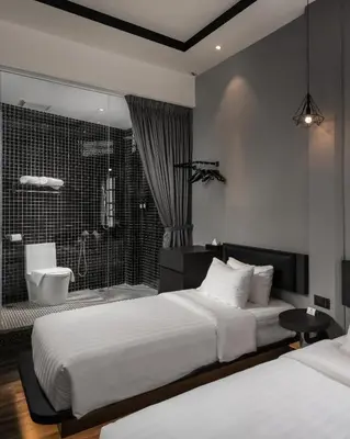 a bedroom with two beds and a bathroom with a shower at Modern Hotel Georgetown in George Town