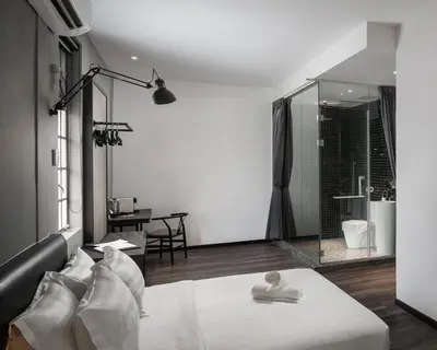a bedroom with a bed and a glass shower at Modern Hotel Georgetown in George Town