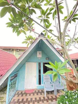 a blue house with two white chairs in front of it at INTAN CHALEt in Pangkor
