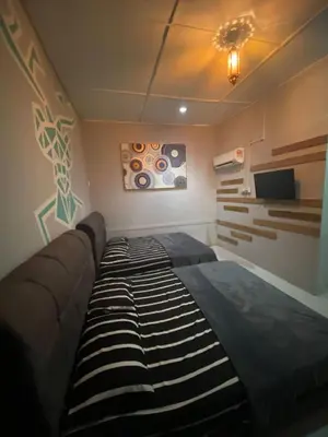 a bedroom with a large bed and a tv at INTAN CHALEt in Pangkor
