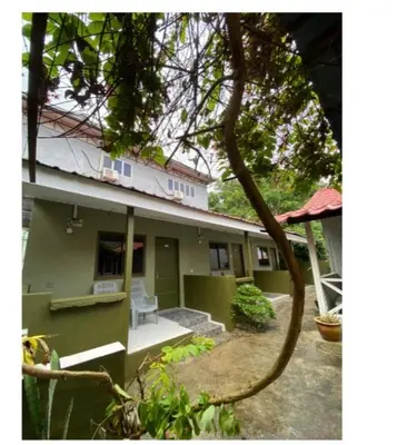 a green house with a chair in the yard at INTAN CHALEt in Pangkor