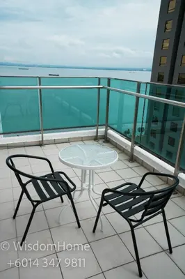 a balcony with two chairs and a table on a building at Seaview Mansion One Georgetown in George Town