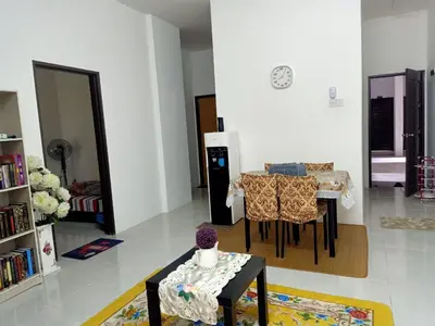 a living room with a table and a dining room at Homestay Musafir Apartment Seri Iskandar 2.0 in Seri Iskandar