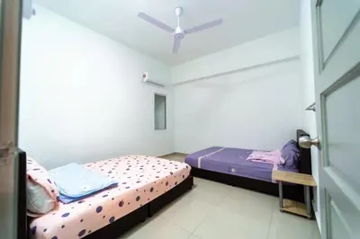 two beds in a room with a ceiling fan at Star Light Homestay 19@ The Venus in Sitiawan