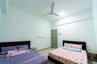 a bedroom with two beds and a ceiling fan at Star Light Homestay 19@ The Venus in Sitiawan
