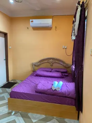 a bed in a room with purple sheets and shoes at PJM HILL VIEW HOMESTAY in Ipoh