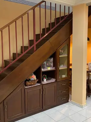 a staircase with a wooden cabinet under a stair case at PJM HILL VIEW HOMESTAY in Ipoh
