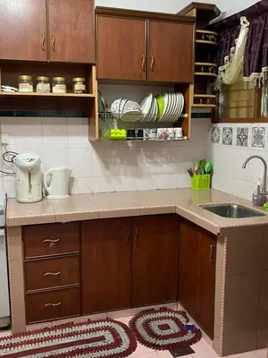 a kitchen with wooden cabinets and a sink and a rug at PJM HILL VIEW HOMESTAY in Ipoh