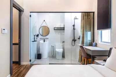 a bathroom with a shower and a toilet and a sink at Wesley Hotel in Bukit Mertajam