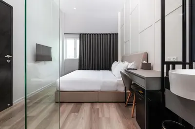 a bedroom with a bed and a desk and a sink at Wesley Hotel in Bukit Mertajam