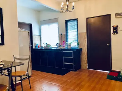 a kitchen with a black cabinet and a table at Sinar Ara homestay in Lunas