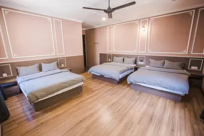 two beds in a room with wooden floors at Barrington Villa @ Golden Hill in Cameron Highlands