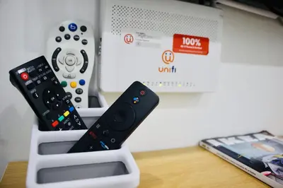 two remote controls sitting in a nintendo wii controller holder at Bismillah Homestay Muslem NETFLIX UNIFI HIGH SPEED in Kamunting