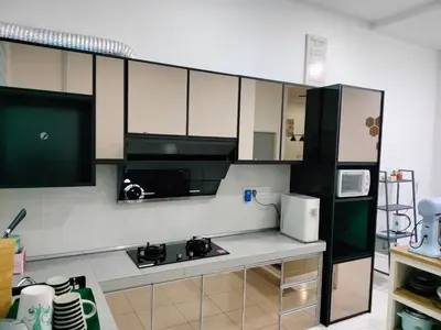 a kitchen with black and white cabinets and a refrigerator at Bismillah Homestay Muslem NETFLIX UNIFI HIGH SPEED in Kamunting