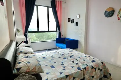 a bedroom with a bed and a blue chair and a window at Haaniy Homestay Casa Kayangan Meru in Ipoh