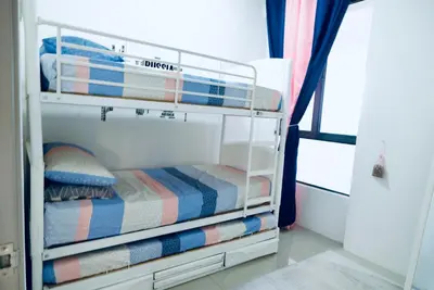 a white bunk bed with striped blankets and pillows at Haaniy Homestay Casa Kayangan Meru in Ipoh
