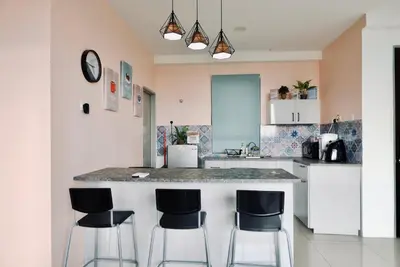 a kitchen with a counter and four bar stools at Haaniy Homestay Casa Kayangan Meru in Ipoh