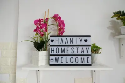 a sign on a shelf with flowers and plants at Haaniy Homestay Casa Kayangan Meru in Ipoh