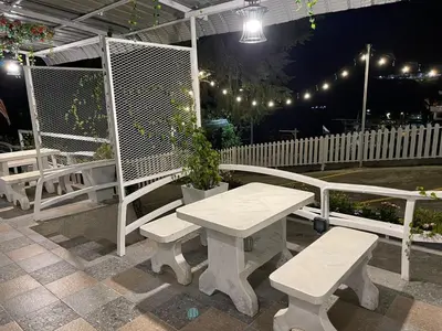 a picnic table and benches on a patio at night at Blue Cabins By Pfordten Cottage in Cameron Highlands