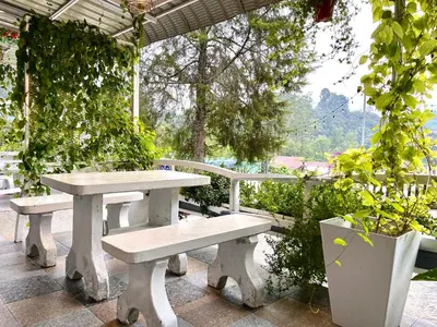 a picnic table and bench on a patio at Blue Cabins By Pfordten Cottage in Cameron Highlands
