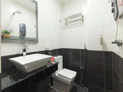 a bathroom with a sink and a toilet and a mirror at Top Garden Hotel in Hutan Melintang