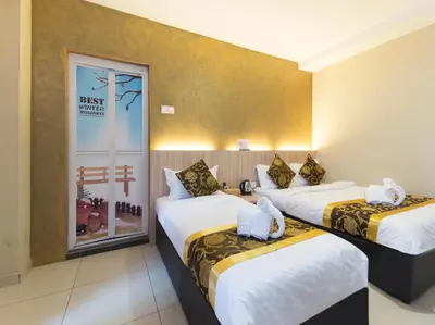 a hotel room with two beds in a room at Top Garden Hotel in Hutan Melintang