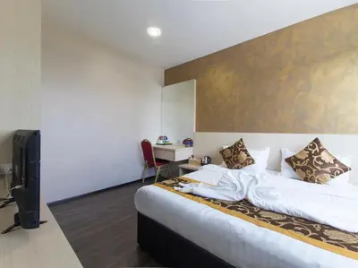 a bedroom with a large bed and a desk at Top Garden Hotel in Hutan Melintang
