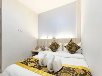 a hotel room with two beds with towels at Top Garden Hotel in Hutan Melintang