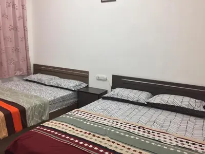 two beds sitting next to each other in a room at Crown imperial in Brinchang