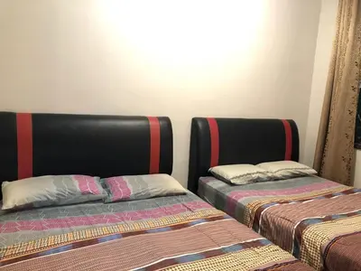 two beds sitting next to each other in a room at Crown imperial in Brinchang