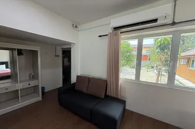 a living room with a chair and a large window at Inapan Taman Herba in Kepala Batas