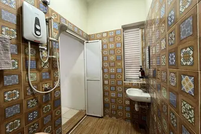 a bathroom with a toilet and a sink in it at Inapan Taman Herba in Kepala Batas