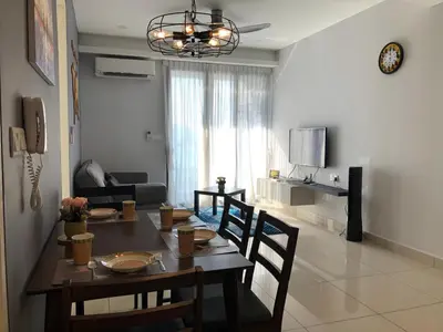 a dining room table and chairs in a living room at Miracle Woodsbury Habour Place Butterworth in Butterworth