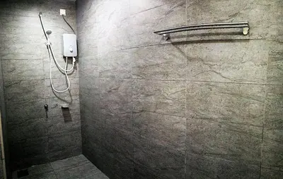a shower in a bathroom with a stone wall at Miracle Woodsbury Habour Place Butterworth in Butterworth