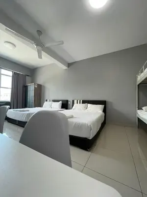 a hotel room with two beds and a table and chairs at Reno Hotel Ipoh in Ipoh