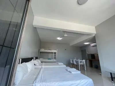 a room with two beds and a table and chairs at Reno Hotel Ipoh in Ipoh